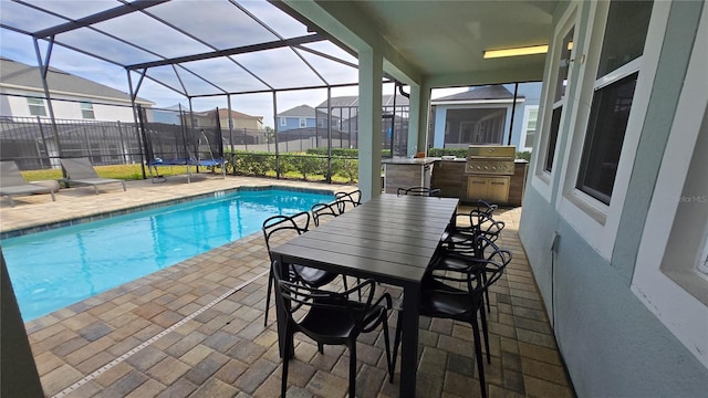 view of pool with a lanai, exterior bar, grilling area, and a patio area