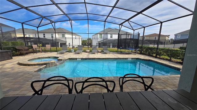 view of swimming pool with an in ground hot tub, a lanai, and a patio