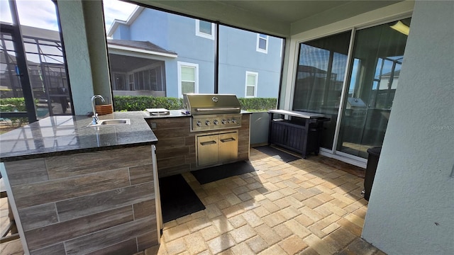 view of patio featuring an outdoor kitchen, grilling area, and sink