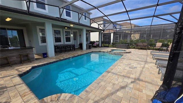 view of pool with an in ground hot tub, a lanai, an outdoor bar, and a patio area