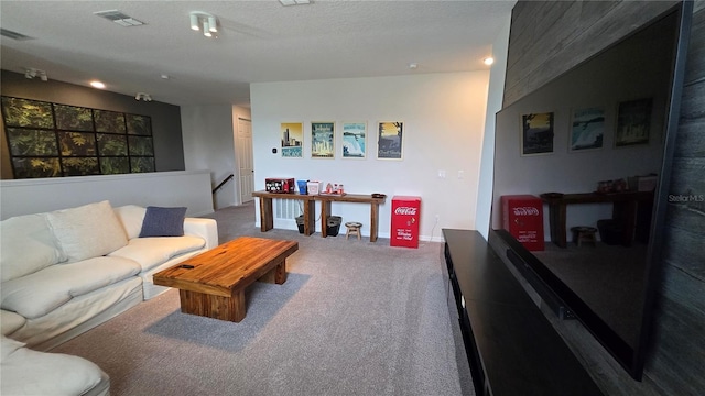 carpeted living room featuring a textured ceiling