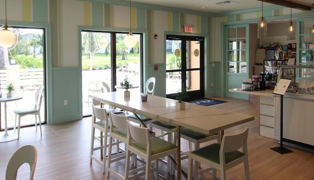 kitchen featuring white cabinetry, light hardwood / wood-style flooring, and decorative light fixtures