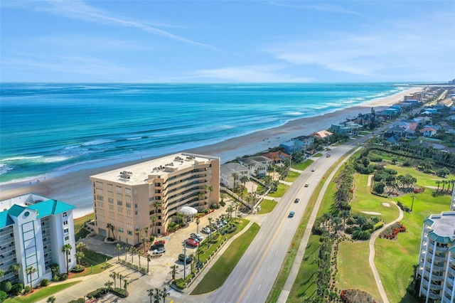 birds eye view of property with a water view and a beach view