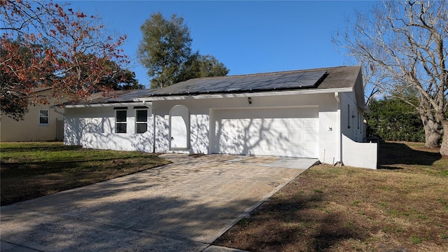 single story home with a garage, a front lawn, and solar panels