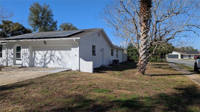 view of home's exterior with a yard, central air condition unit, and solar panels