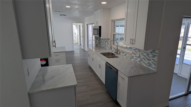 kitchen featuring sink, dark wood-type flooring, white cabinetry, black dishwasher, and light stone countertops