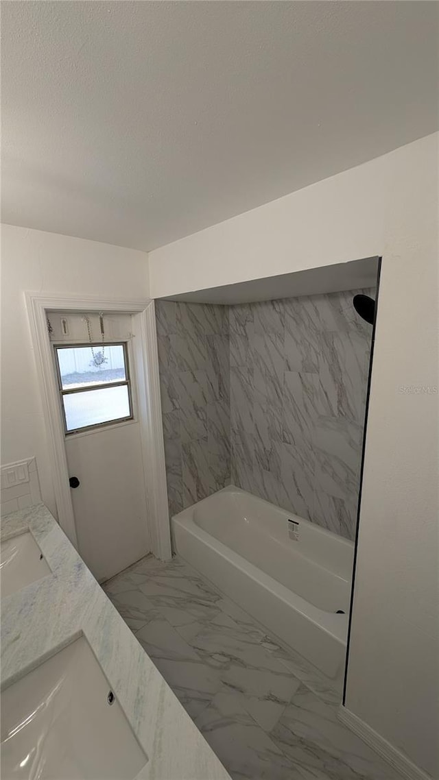 bathroom featuring vanity, a bathing tub, and a textured ceiling