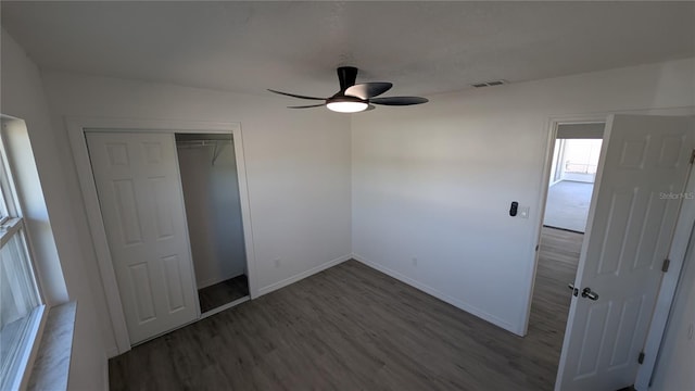 unfurnished bedroom featuring hardwood / wood-style floors, ceiling fan, and a closet