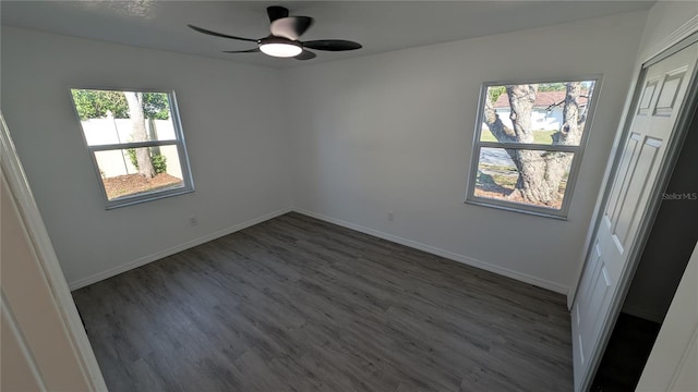 unfurnished room with dark hardwood / wood-style flooring and ceiling fan