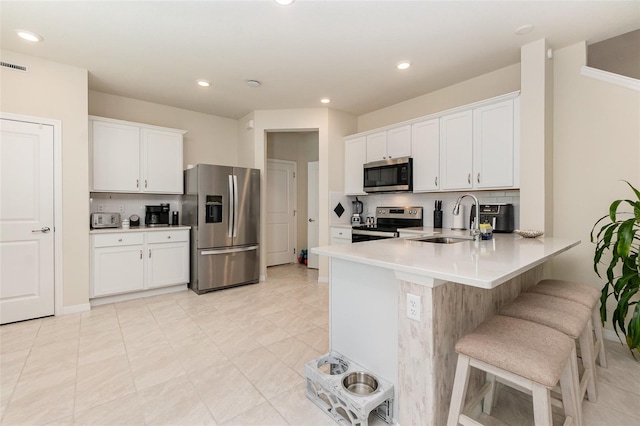 2623 Buena View Rd, Kissimmee, FL 34746 - kitchen featuring stainless steel appliances, a sink, a peninsula, a kitchen breakfast bar, and light countertops