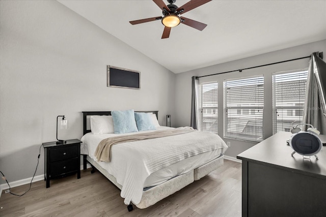 bedroom with lofted ceiling, ceiling fan, wood finished floors, and baseboards