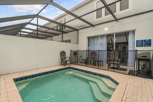 view of swimming pool with glass enclosure, a patio area, and a pool