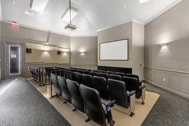 home theater room with visible vents, wainscoting, light colored carpet, ornamental molding, and a decorative wall