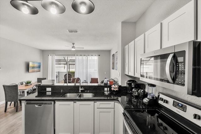 kitchen featuring white cabinetry, visible vents, appliances with stainless steel finishes, and a sink