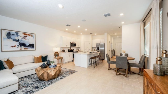 living room featuring sink and light tile patterned floors