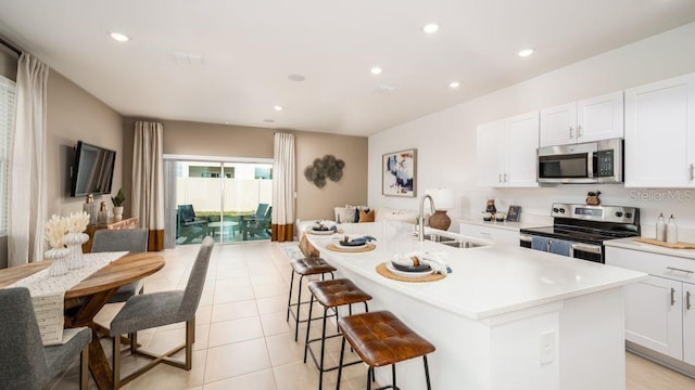 kitchen featuring appliances with stainless steel finishes, sink, a center island with sink, and white cabinets