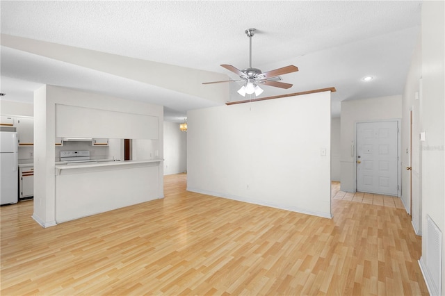 unfurnished living room with lofted ceiling, a textured ceiling, ceiling fan, and light hardwood / wood-style flooring