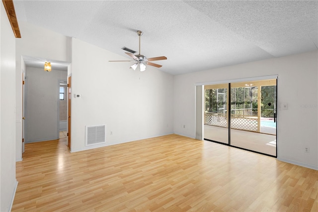 spare room with lofted ceiling, ceiling fan, a textured ceiling, and light wood-type flooring