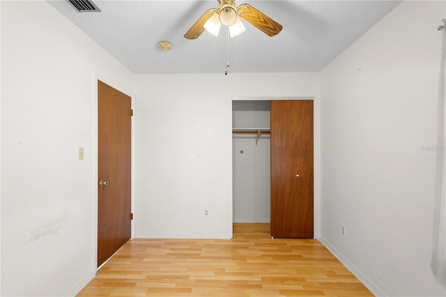 unfurnished bedroom with a closet, a textured ceiling, and light wood-type flooring