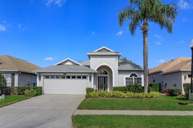 view of front of home with a garage and a front lawn