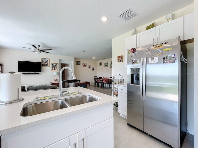 kitchen featuring sink, white cabinets, light tile patterned floors, ceiling fan, and stainless steel fridge with ice dispenser