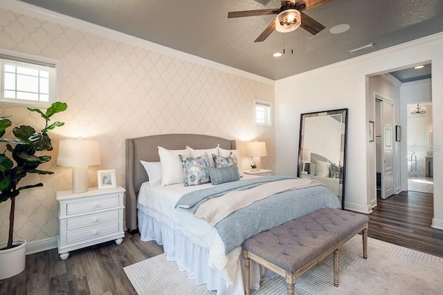 bedroom featuring ceiling fan with notable chandelier, ornamental molding, and dark hardwood / wood-style floors