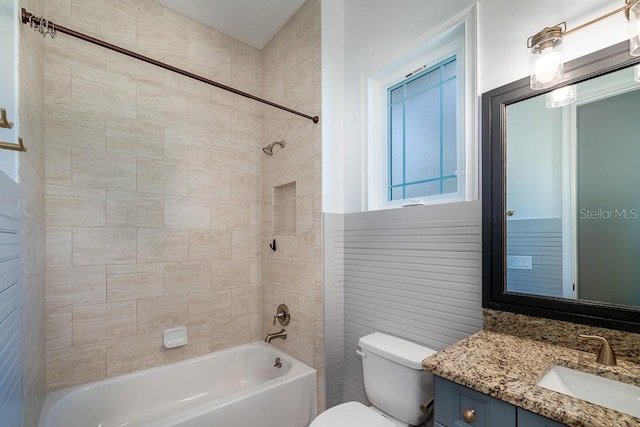 full bathroom featuring tiled shower / bath, vanity, and toilet