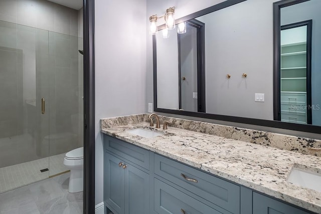 bathroom featuring an enclosed shower, vanity, and toilet