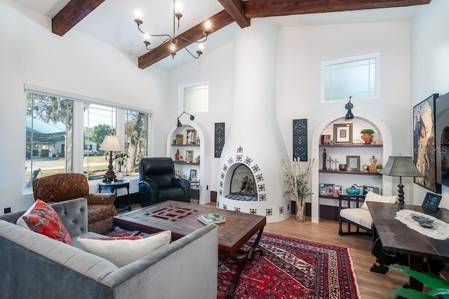 living room with beamed ceiling, high vaulted ceiling, hardwood / wood-style floors, and a fireplace