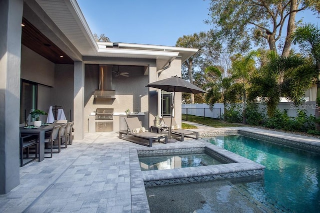 view of swimming pool featuring area for grilling, an outdoor kitchen, a patio, and an in ground hot tub