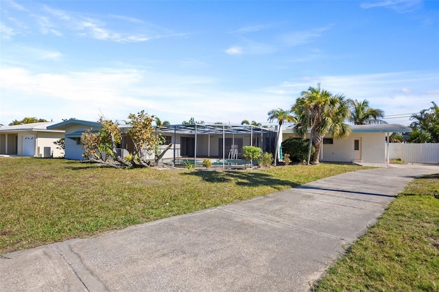 view of front of home featuring a front lawn and glass enclosure