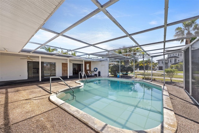 view of swimming pool featuring a patio, ceiling fan, and glass enclosure