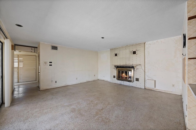 unfurnished living room with a brick fireplace and a textured ceiling