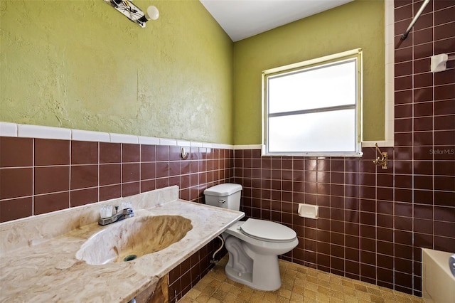 bathroom with tile walls, sink, and toilet