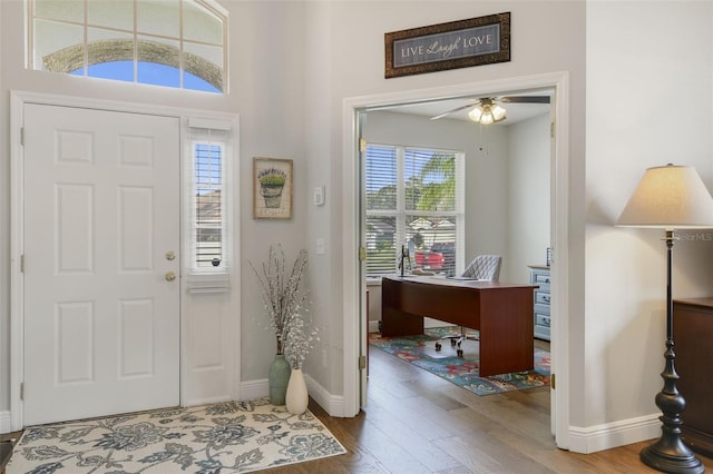 foyer entrance with wood-type flooring and ceiling fan