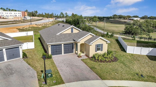 view of front of home with a garage, decorative driveway, a fenced backyard, and a gate