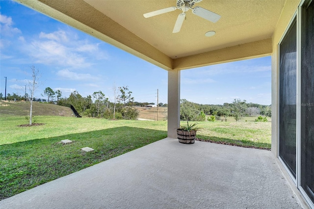 view of patio / terrace featuring ceiling fan and a rural view