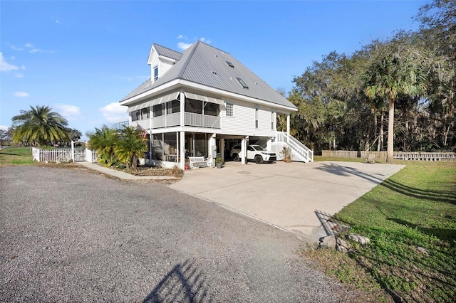 view of front of house featuring a carport, a sunroom, and a front yard