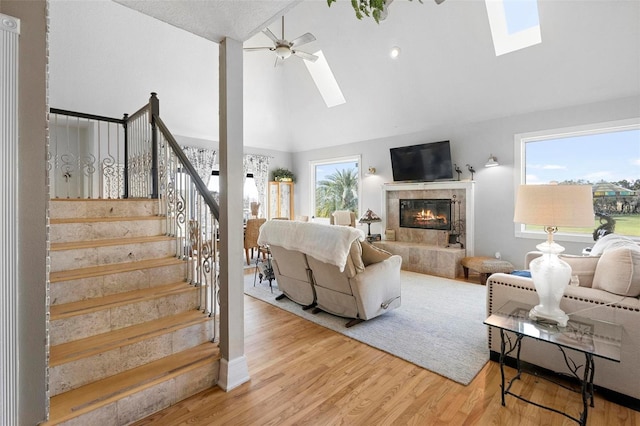 living room with a wealth of natural light, ceiling fan, and a skylight