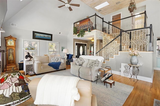 living room with hardwood / wood-style flooring, high vaulted ceiling, and ceiling fan