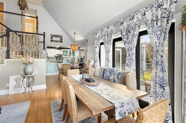 dining space featuring a healthy amount of sunlight, high vaulted ceiling, and light wood-type flooring