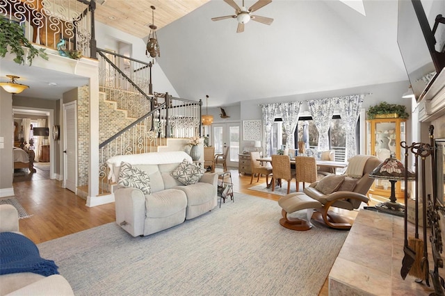 living room with french doors, high vaulted ceiling, and hardwood / wood-style floors