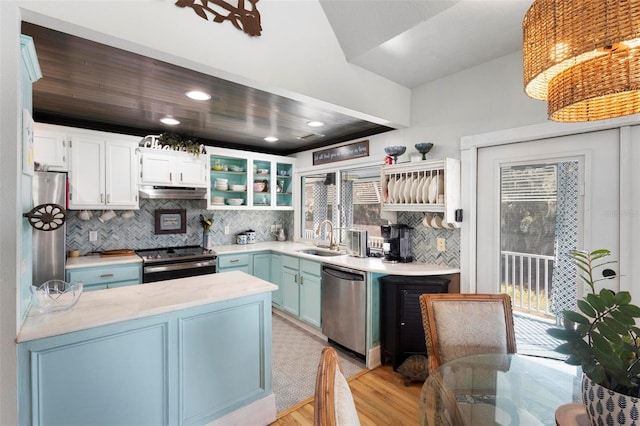 kitchen featuring blue cabinetry, sink, decorative light fixtures, stainless steel appliances, and white cabinets