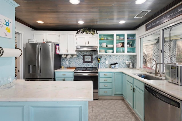 kitchen featuring appliances with stainless steel finishes, sink, white cabinets, ornamental molding, and light stone countertops