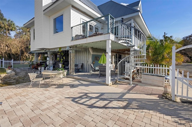 rear view of house featuring a balcony and a patio