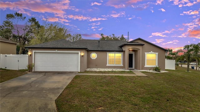 ranch-style home with an attached garage, driveway, a gate, stucco siding, and a front lawn