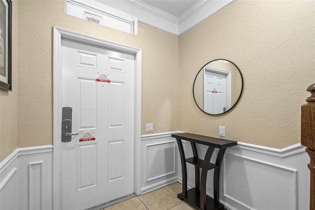 tiled entryway featuring ornamental molding