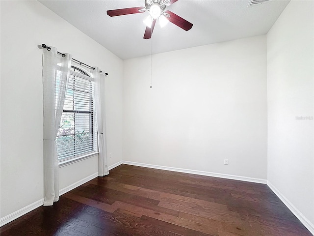 empty room with dark hardwood / wood-style floors and ceiling fan