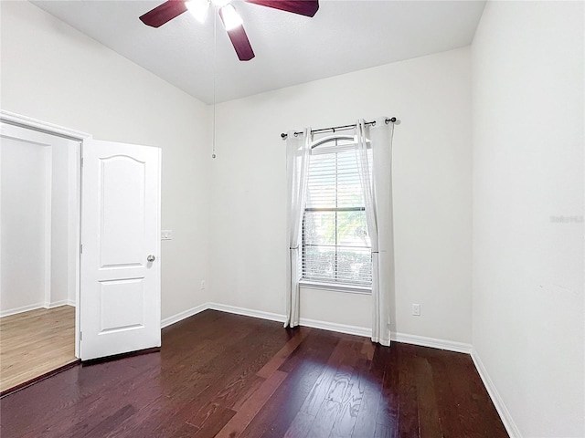 spare room with dark hardwood / wood-style flooring and ceiling fan