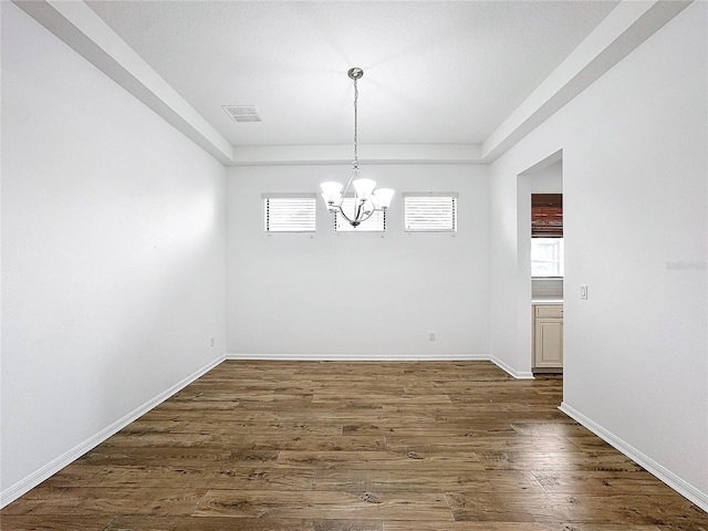 unfurnished dining area with dark hardwood / wood-style flooring and a chandelier